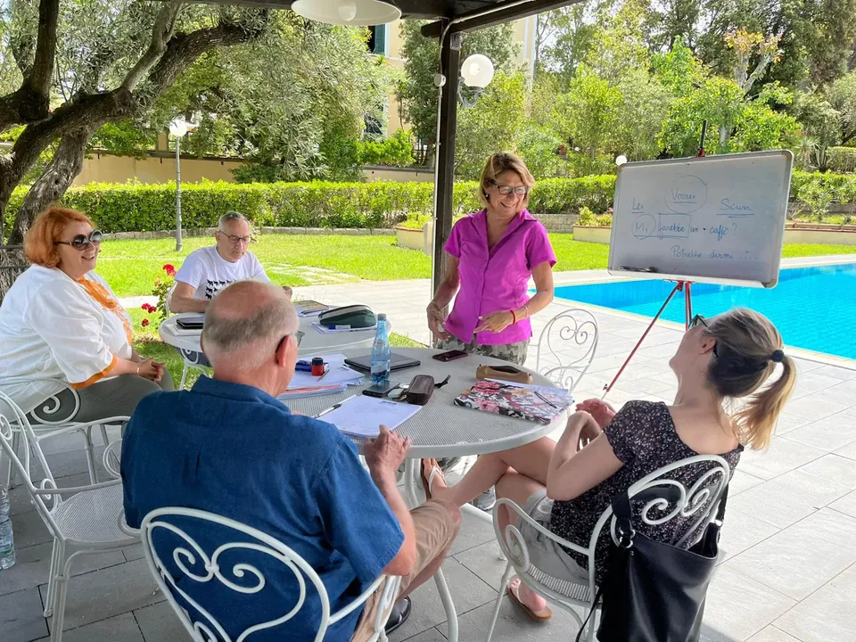 Cours d’italien pour adultes avec une enseignante et un tableau dans le jardin de la Villa Teresa