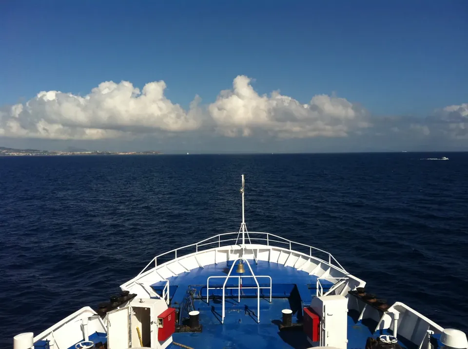 Vue sur la mer et la côte depuis la proue bleue et blanche d’un ferry