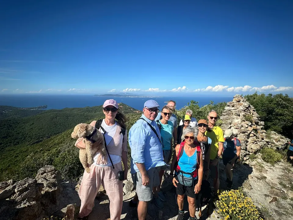 Un grupo de senderistas en un mirador rocoso sobre el mar