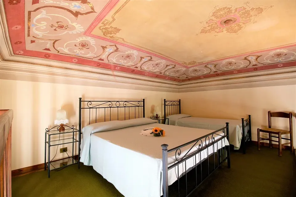 Sleeping area with a decorated ceiling and several beds