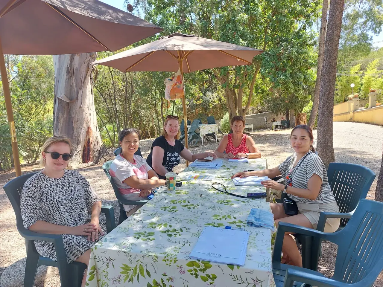 Kleine internationale Lerngruppe an einem Tisch im Garten der Villa Teresa