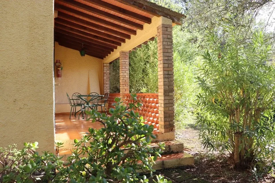 Exterior de Villetta La Paolina con veranda cubierta entre la vegetación