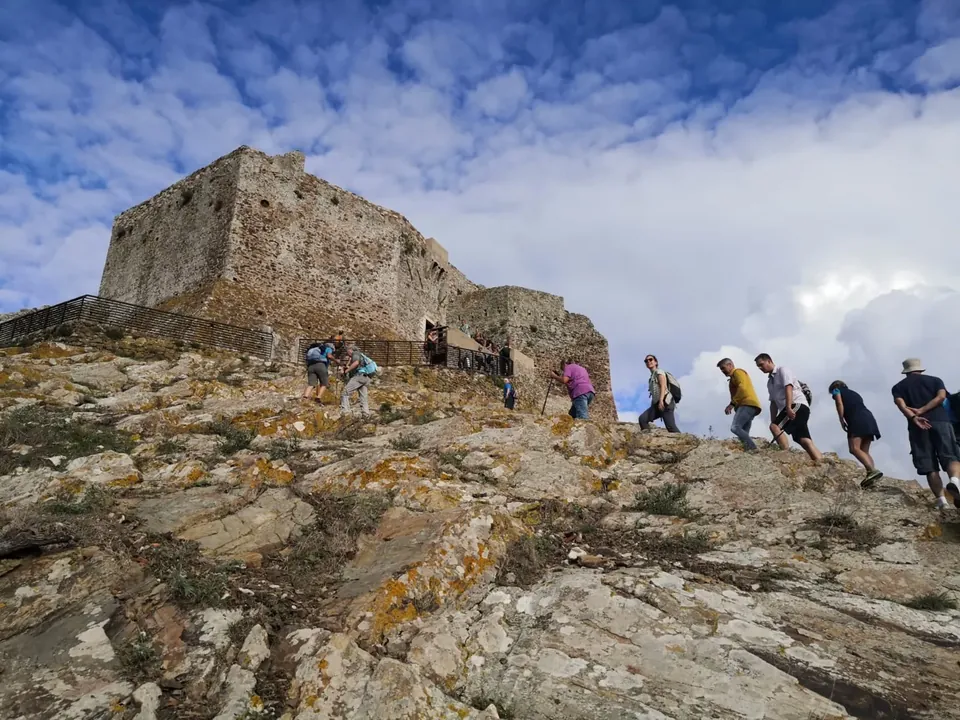 Grupo subiendo por el sendero rocoso hacia la fortaleza del Volterraio