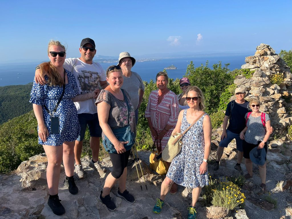 Gruppe auf einem felsigen Aussichtspunkt mit Meerblick
